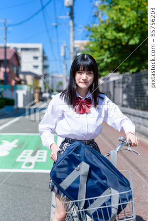背著風,笑著騎自行車上學的女高中生。 背著風,笑著騎自行車上學的女高中生。 85756203