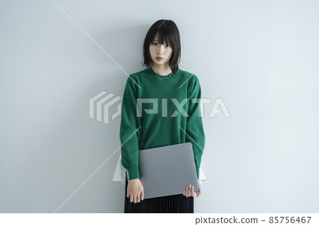 使用便攜式計算機的婦女在屋子裡 使用便攜式計算機的婦女在屋子裡 85756467