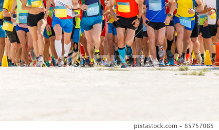 Large group of sportsmen starting running contest at desert Large group of sportsmen starting running contest at desert 85757085