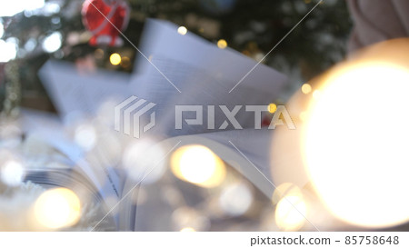 Book in front of Christmas tree. New Year celebration. Book in front of Christmas tree. New Year celebration. 85758648