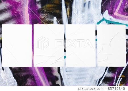 colorful urban wall with four wrinkled glued poster templates 85759840