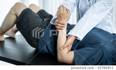 Female physiotherapist doing healing treatment and rehabilitation injured arms and wrist of patient by stretching 85760953