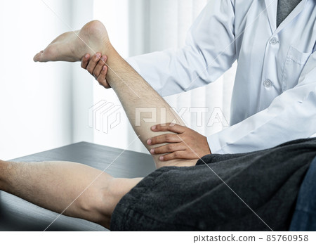 Female physiotherapist doing healing treatment and rehabilitation injured legs and ankle of patient by stretching 85760958