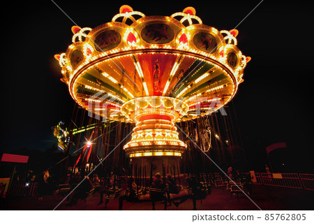Colorful chain swing carousel in motion at amusement park at night. 85762805