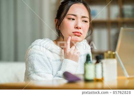 一個年輕的女人患有粗糙的皮膚 一個年輕的女人患有粗糙的皮膚 85762828