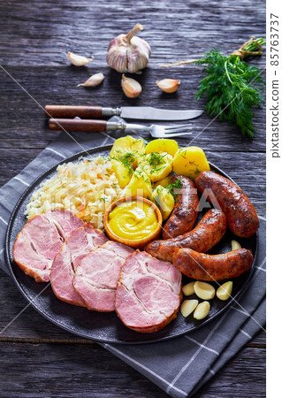 bratwurst, pork, potatoes, sauerkraut on a plate bratwurst, pork, potatoes, sauerkraut on a plate 85763737
