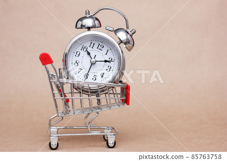 Metal alarm clock in shopping cart. The concept of time Metal alarm clock in shopping cart. The concept of time 85763758
