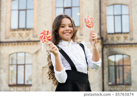 Picking flavour is hardest part. Schoolgirl choosing sweets Picking flavour is hardest part. Schoolgirl choosing sweets 85763874