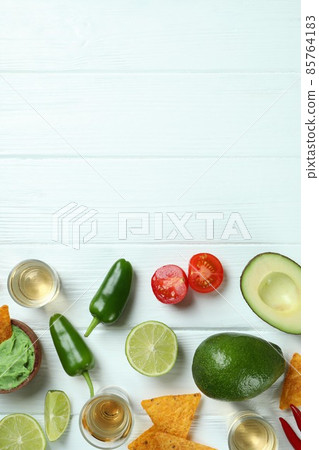 Party concept with tequila, guacamole and chips Party concept with tequila, guacamole and chips 85764183