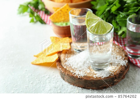 Party concept with tequila, guacamole and chips Party concept with tequila, guacamole and chips 85764202