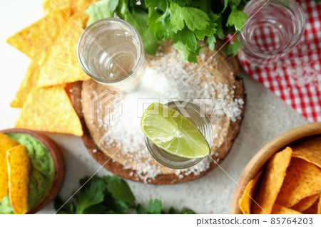 Party concept with tequila, guacamole and chips Party concept with tequila, guacamole and chips 85764203
