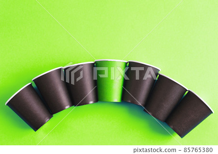 Eco-friendly disposable brown and green paper cups on green background. Ecology concept. Eco-friendly disposable brown and green paper cups on green background. Ecology concept. 85765380