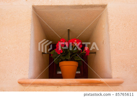 Spanish window with begonia in flowerpot. Spanish window with begonia in flowerpot. 85765611