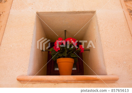 Spanish window with begonia in flowerpot. Spanish window with begonia in flowerpot. 85765613
