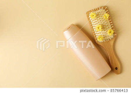 Blank bottle of shampoo and hair brush on beige background Blank bottle of shampoo and hair brush on beige background 85766413
