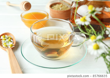 Concept of cooking chamomile tea on white wooden table Concept of cooking chamomile tea on white wooden table 85766635