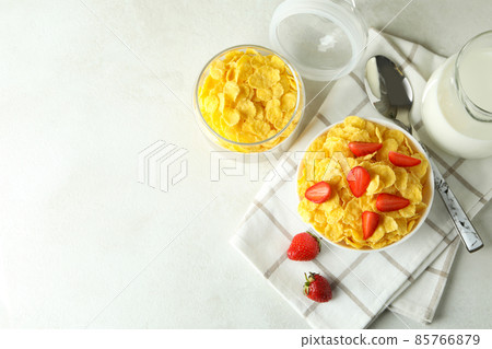 Concept of tasty breakfast with cornflakes on white textured table Concept of tasty breakfast with cornflakes on white textured table 85766879