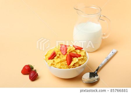 Concept of tasty breakfast with cornflakes on beige background Concept of tasty breakfast with cornflakes on beige background 85766881