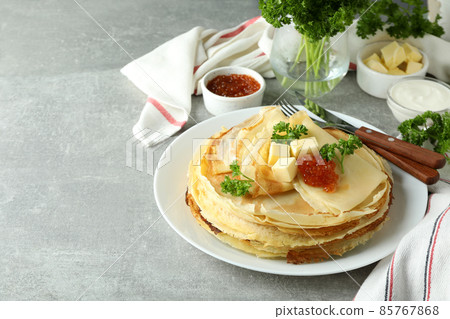 Concept of tasty food with crepes on gray textured table Concept of tasty food with crepes on gray textured table 85767868