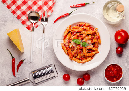 Classic italian pasta penne alla arrabiata with fresh basil on a light background 85770039