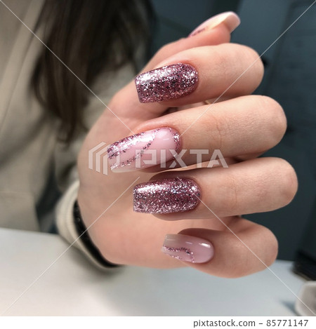 Hands of a woman with pink manicure on nails with design.Manicure beauty salon concept. Empty place for text or logo. 85771147