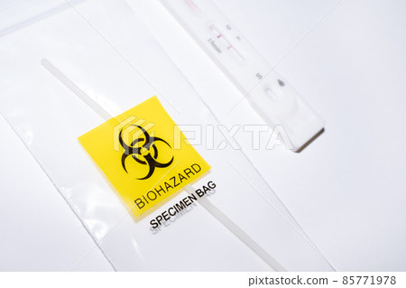 Positive covid self-test and swab in biohazard bag 85771978