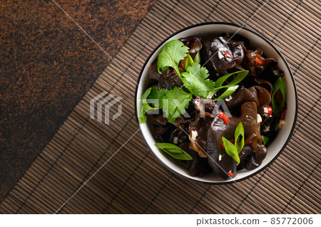 Salad of chinese pickled tree black muer mushrooms in bowl on brown background. 85772006