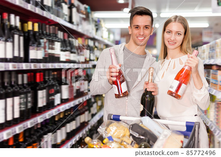 Nice family pair deciding what wine to buy Nice family pair deciding what wine to buy 85772496