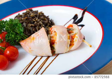 Photography of plate with stuffed by egg, pepper and green squid with wild rice and cherry tomato 85772568