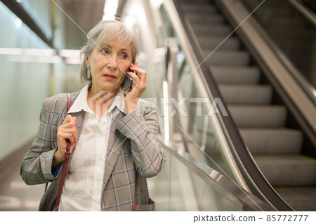 Senior lady having telephone conversarion in mall 85772777