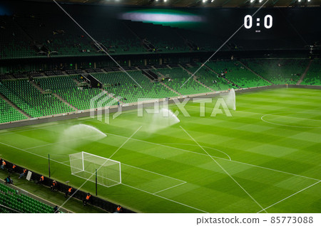 An open football stadium with empty stands with green seats. 85773088