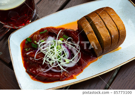 Baked sausages with red onion and bread 85773100