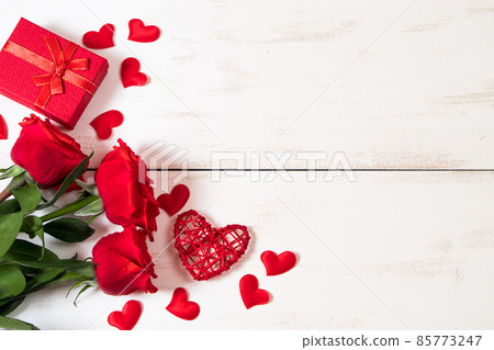 Red roses and hearts on white wooden background. Valentine's day, place for text. Red roses and hearts on white wooden background. Valentine's day, place for text. 85773247