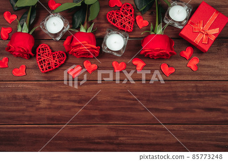 Red roses and hearts on dark wooden background. Valentine's day postcard concept. Red roses and hearts on dark wooden background. Valentine's day postcard concept. 85773248