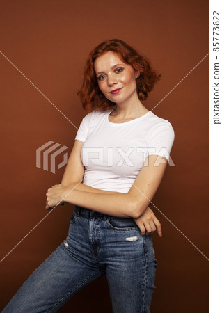 young pretty redhead girl posing cheerful on warm brown background, lifestyle people concept young pretty redhead girl posing cheerful on warm brown background, lifestyle people concept 85773822