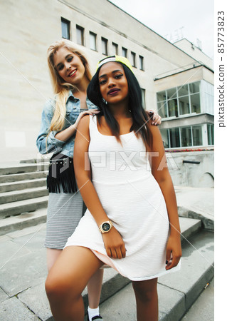 Two teenage diverse nations girls infront of university building smiling, having fun traveling europe, lifestyle people concept Two teenage diverse nations girls infront of university building smiling, having fun traveling europe, lifestyle people concept 85773823