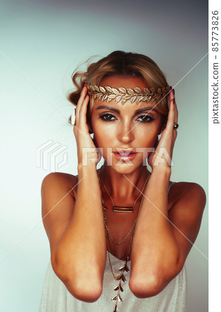 young blond woman dressed like ancient greek godess, gold jewelry close up isolated, beautiful girl hands manicured red nails 85773826