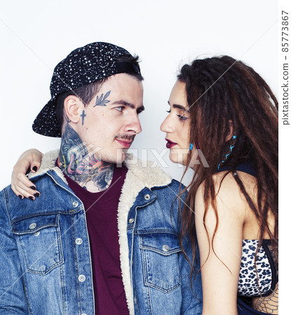 Young couple together. guy with tattoo, girlfriend wearing dreadlocks having fun on white background Young couple together. guy with tattoo, girlfriend wearing dreadlocks having fun on white background 85773867