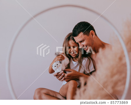 Happy affectionate loving single father and cute small child daughter bonding embracing laughing sit on sofa. 85773869