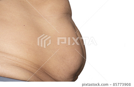 Closeup shot of overweight overweight woman measuring belly fat with hands. Isolated on white background Closeup shot of overweight overweight woman measuring belly fat with hands. Isolated on white background 85773908