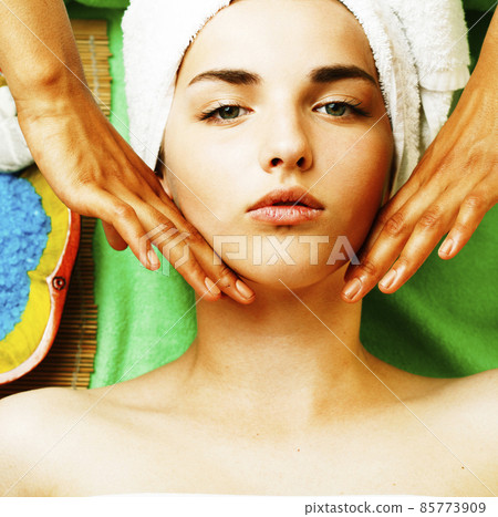 Attractive lady getting spa treatment in salon, close up asian tan hands on face 85773909