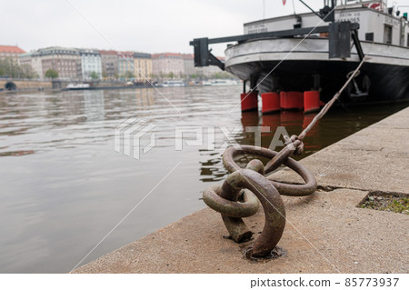 Ship or vessel moored on the embankment of the Vlatva river in Prague in cloudy and grey autumn day.  85773937
