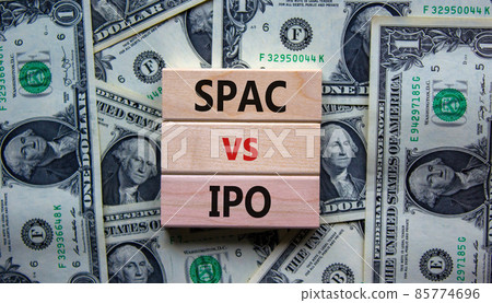 SPAC vs IPO symbol. Blocks with words 'SPAC, special purpose acquisition company' and 'IPO, initial public offering' on background from dollar bills, copy space. Business and SPAC vs IPO concept. 85774696