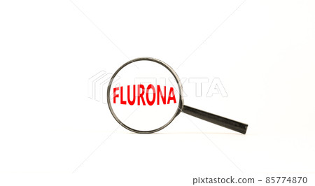Covid-19 corona and flu flurona symbol. The concept word flurona. Magnifying glass. Beautiful white table, white background. Medical covid-19 corona and flu flurona concept. Copy space. Covid-19 corona and flu flurona symbol. The concept word flurona. Magnifying glass. Beautiful white table, white background. Medical covid-19 corona and flu flurona concept. Copy space. 85774870