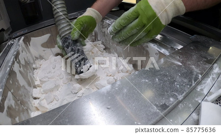 Man cleans details printed on an industrial 3D printer from white plastic powder Man cleans details printed on an industrial 3D printer from white plastic powder 85775636
