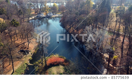 Arial drone view flight over lake in park on sunny autumn day Arial drone view flight over lake in park on sunny autumn day 85775639