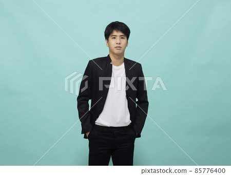 Handsome Asian man in a black suit looking at camera Handsome Asian man in a black suit looking at camera 85776400
