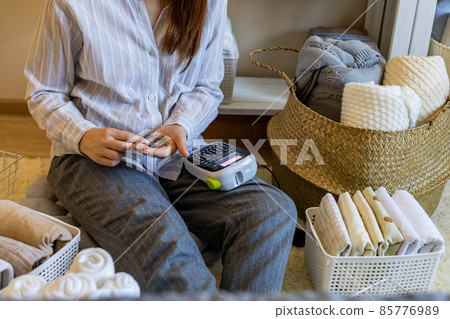 Woman neatly folded linens and towels use Marie Kondo method with sticky label tags Woman neatly folded linens and towels use Marie Kondo method with sticky label tags 85776989