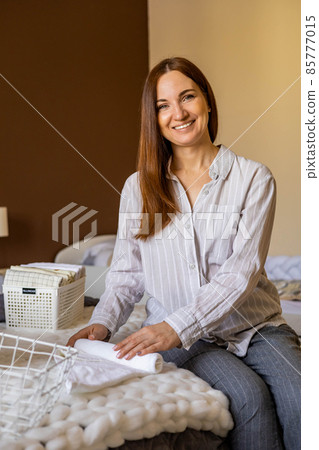 Top view female hands neatly folded white clean towels in case box use Marie Kondo organizing method 85777015
