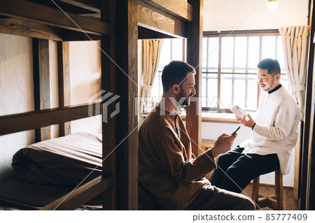 Two men talking in a bunk bed 85777409